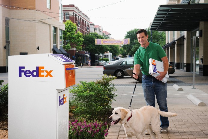 man walking dog to FedEx dropbox
