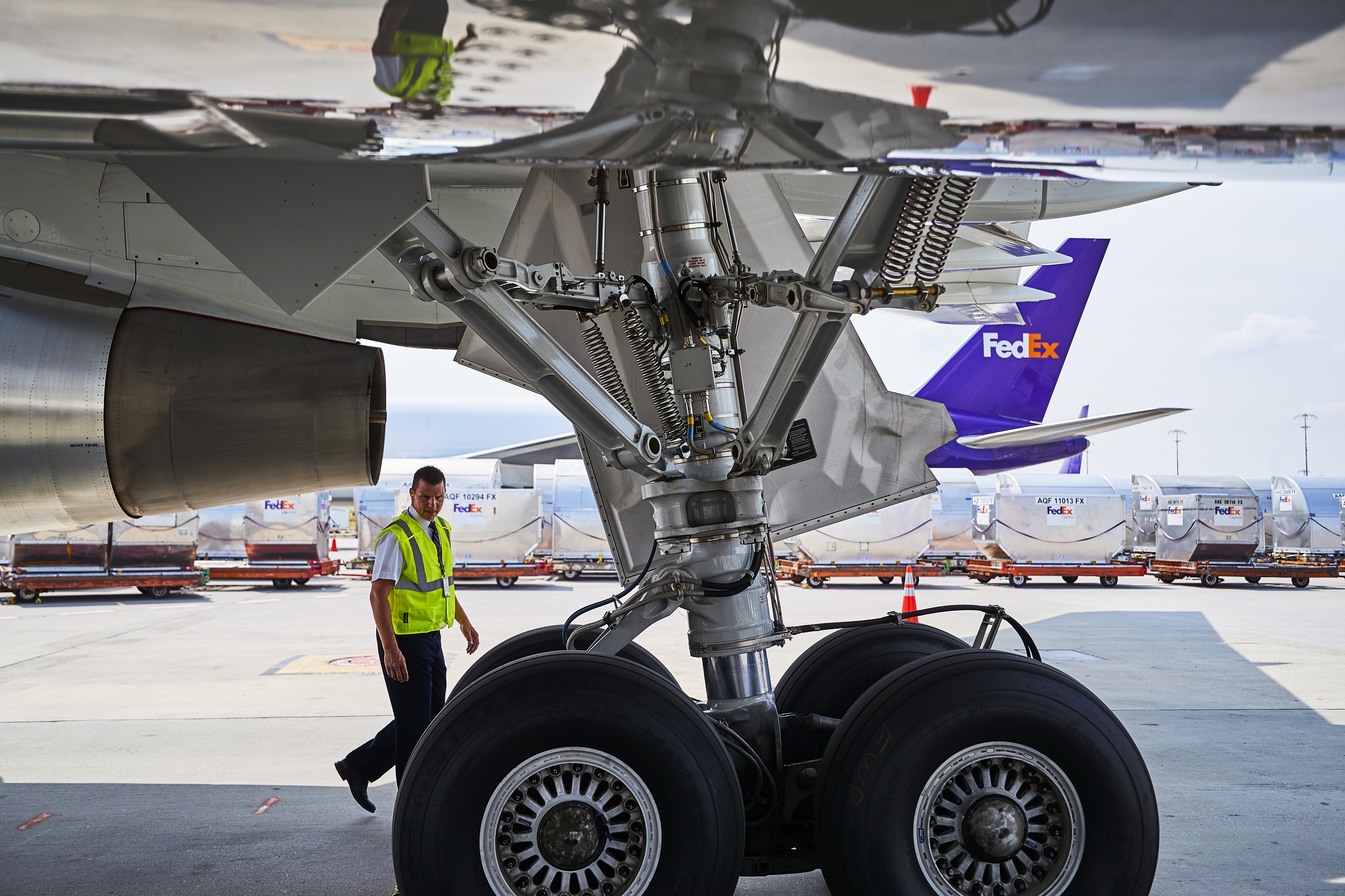 FedEx worker walking underneath a plane at a FedEx airport hub