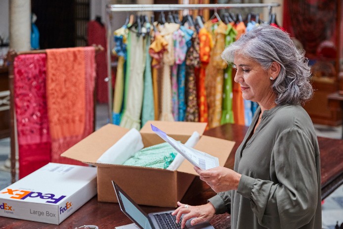 Woman applying label pouch to package
