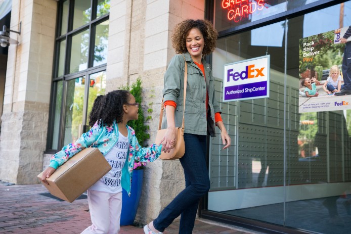 Mère et fille déposant un colis chez FedEx