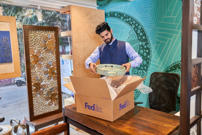Person holding bowl to place in a FedEx box