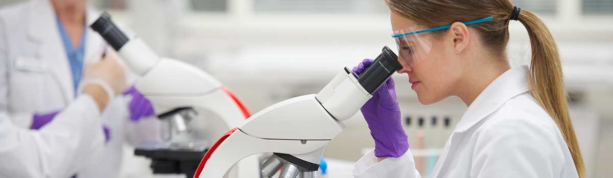 Femme qui regarde dans un microscope