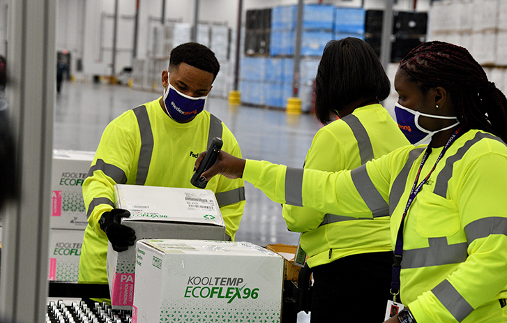 Des employés de FedEx expédient des vaccins