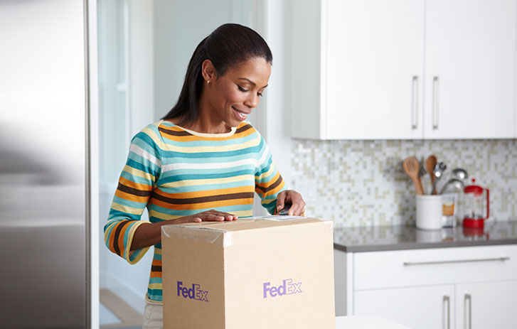 Femme ouvrant un colis FedEx