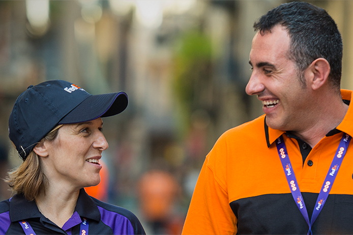 FedEx and TNT employees smiling at each other