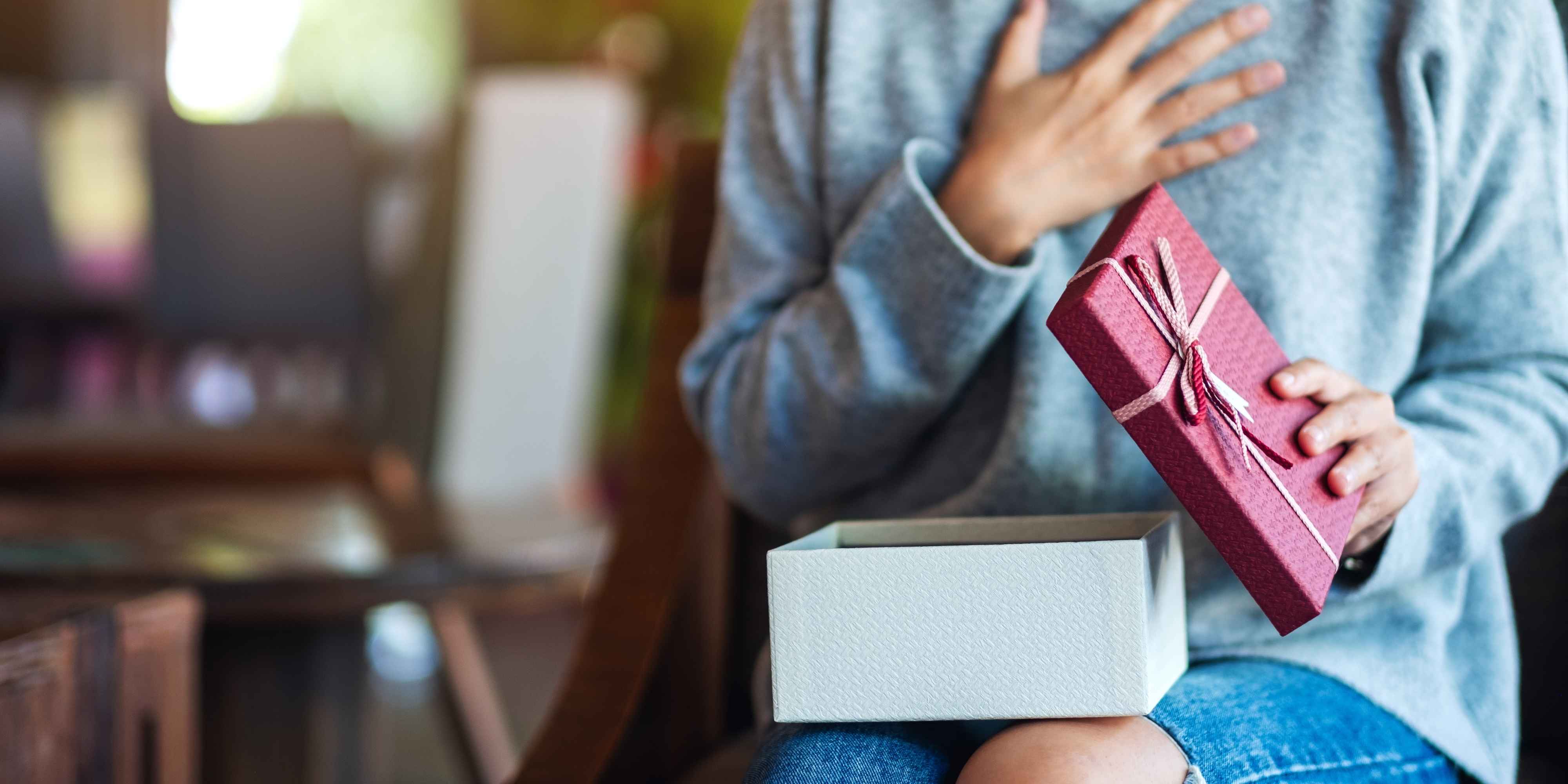 Frau, die ein Geschenk öffnet.