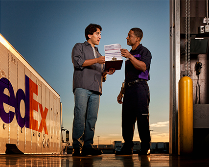 Trabalhador num armazém a aplicar uma etiqueta FedEx a uma caixa