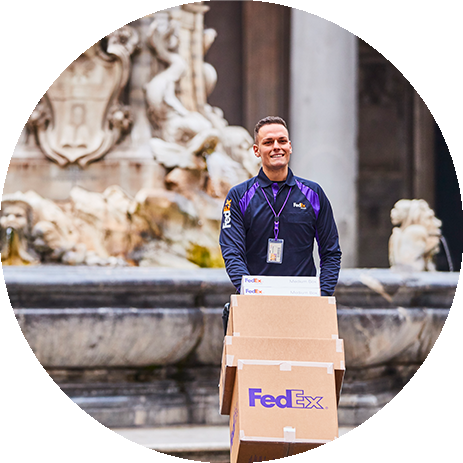 Smiling FedEx courier walking away from an elaborate fountain 