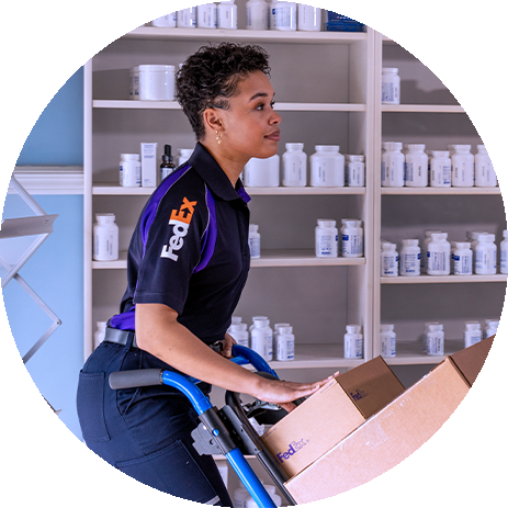Estafeta da FedEx a empurrar um carrinho de carga numa farmácia