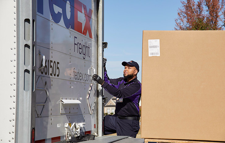 Empleado de FedEx cargando un camión de carga