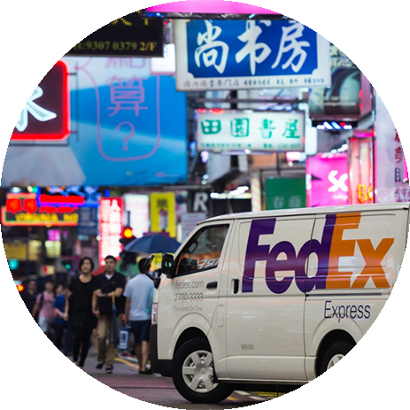 FedEx van on the street in Hong Kong at night with bright colorful signs all around