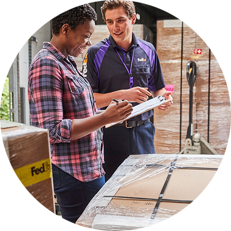 FedEx courier talking to a customer beside a pallet