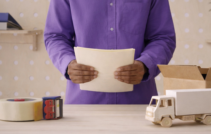 Person standing behind table with shipping supplies