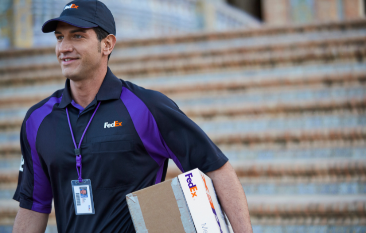 Dipendente FedEx che porta un collo giù per le scale