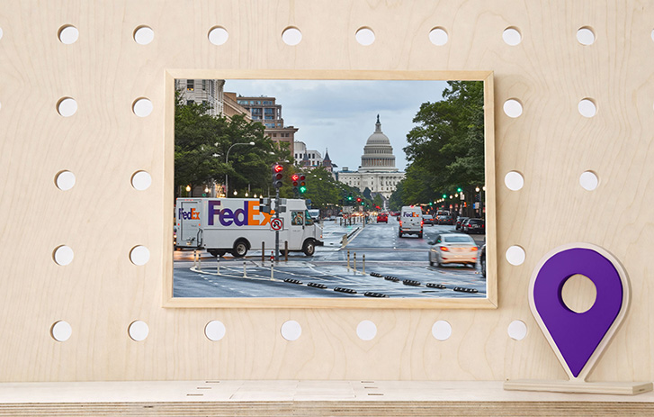 Pegboard with a wooden map location icon and a picture of a FedEx van driving towards the U.S. Whit House