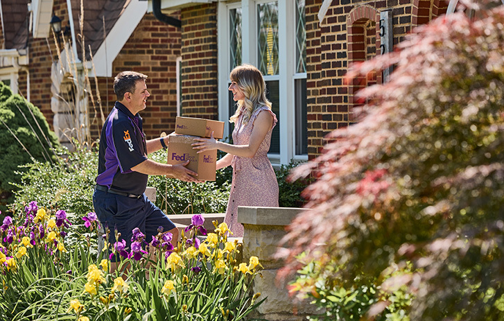 FedEx employee delivering packages to a woman