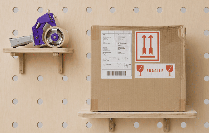 Tape gun and a package with a shipping label and fragile sticker on it