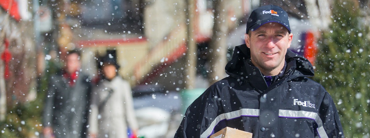 Courier delivery package while it's snowing outside