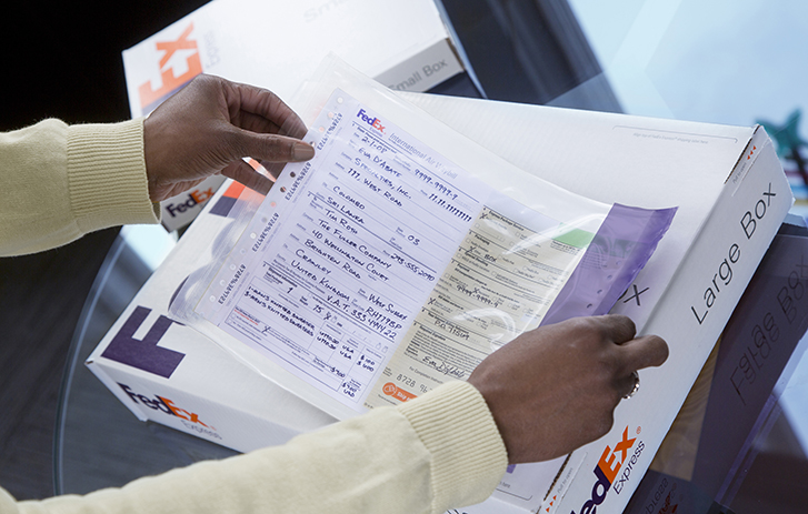 Person adding an airway bill to a FedEx box