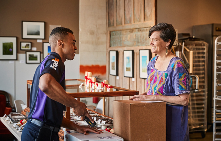 A FedEx courier picks up a package from an Asian clothing store.
