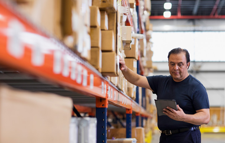 man on a tablet in a warehouse
