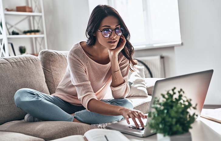 Person on a couch looking at their laptop