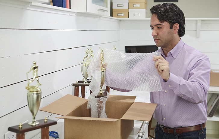 Man packing a trophy in a box