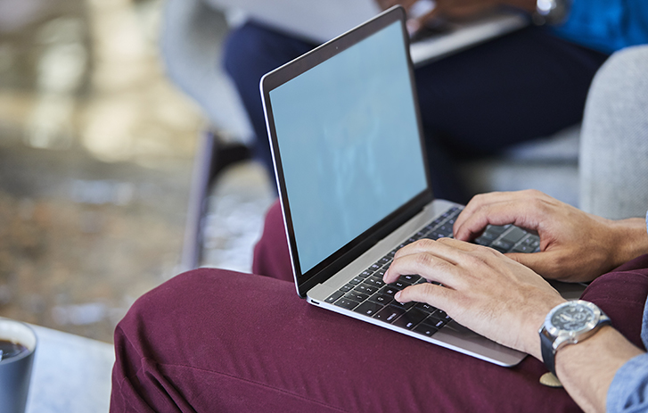 Man typing on laptop in his lap