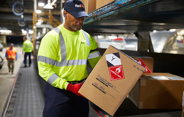 FedEx Worker carrying packages on a handcart