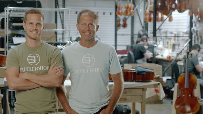 Father and Son, who are business owners, stand in the shop