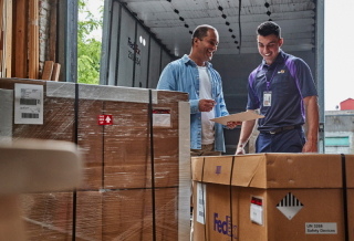 FedEx employee and customer smiling in a warehouse
