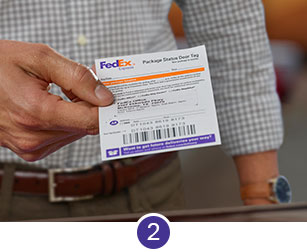 A man holding a door tag tracking label