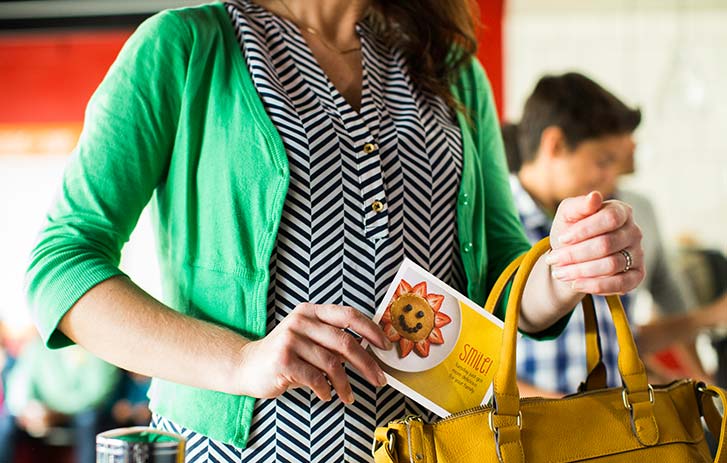 woman putting a postcard in a purse