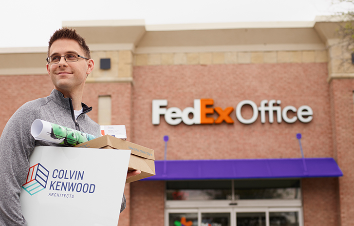 Convenience Man standing outside of FedEx Office holding print products