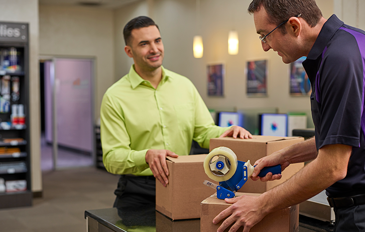 Employee helping customer pack a shipment