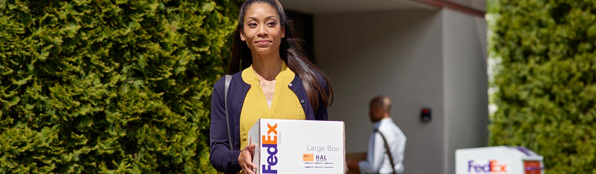 A Customer picking up her box after using FedEx Delivery Manager