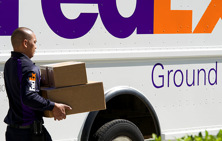 A FedEx driver delivering two boxes
