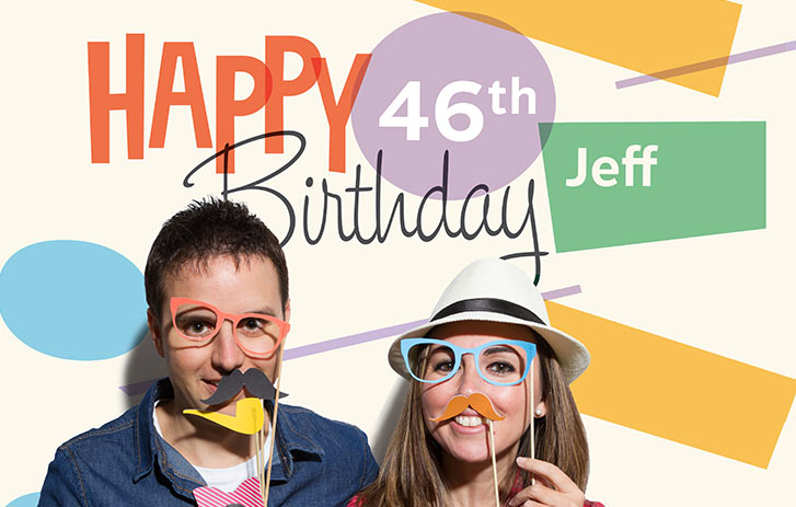 Two women in front of a happy birthday poster