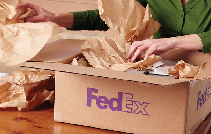 Woman packing a FedEx box