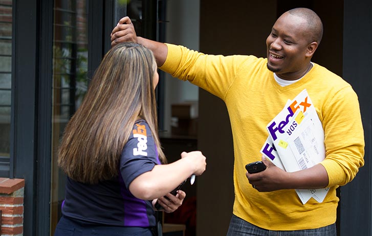 A man conversating with a FedEx delivery driver