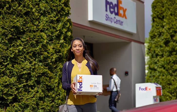 A women walking out of a hold at location center with a package.
