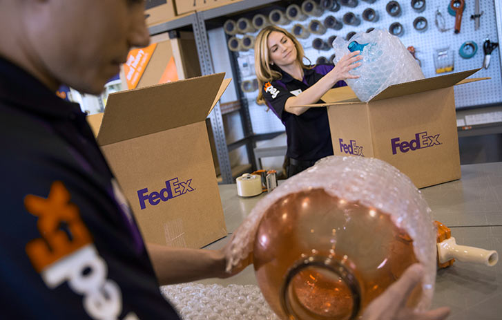 FedEx Office associates packing items in-store FedEx Office associates packing items in-store