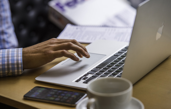 man using laptop on small table