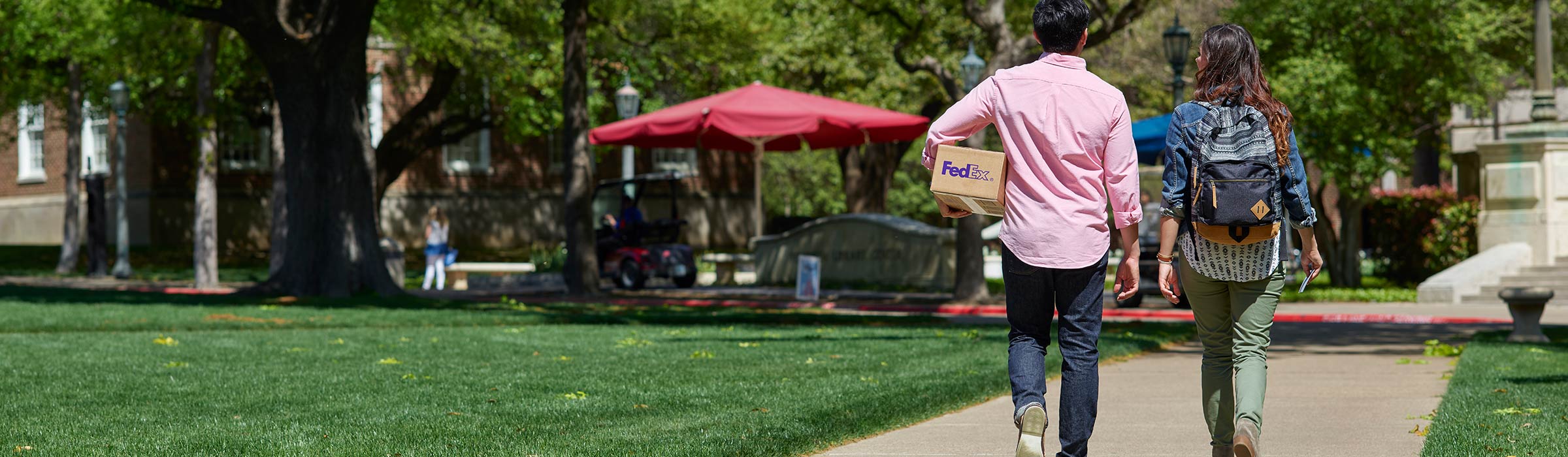 Couple walking with FedEx package