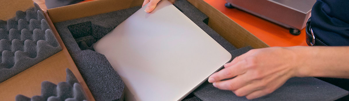 FedEx associate packing a laptop