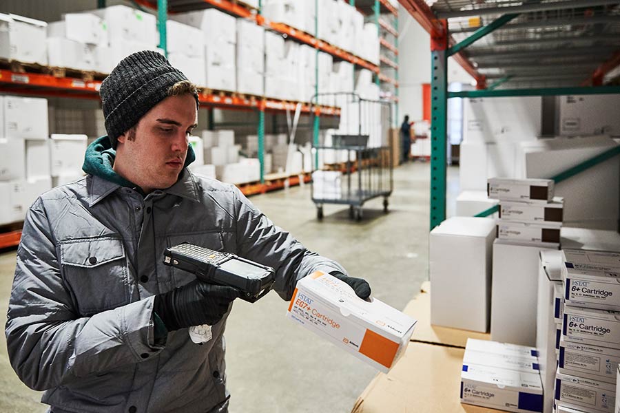 Courier scans boxes in warehouse