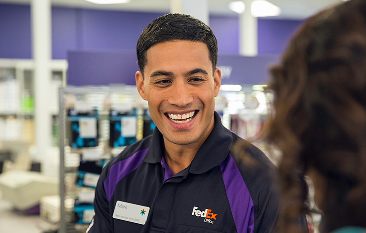 FedEx employee helping customer FedEx employee helping customer