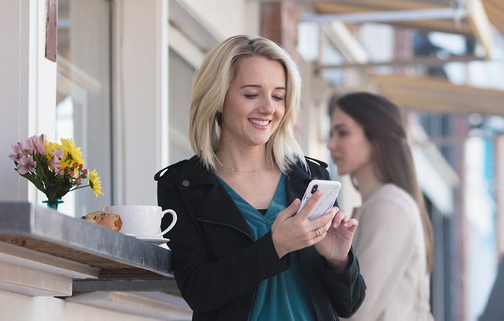 A woman using a smart phone at a cafe
