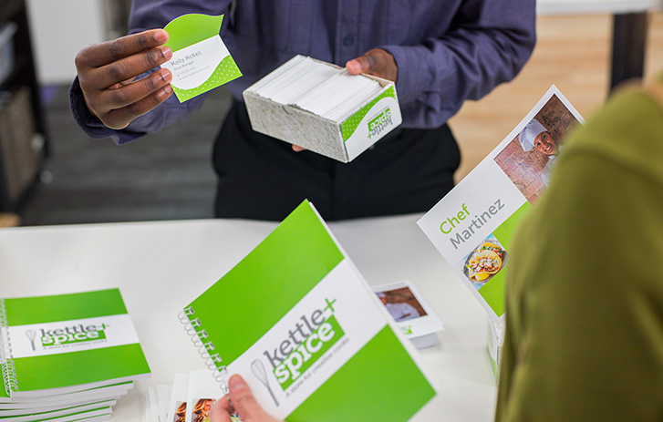 A customer looking at different print products with a FedEx associate