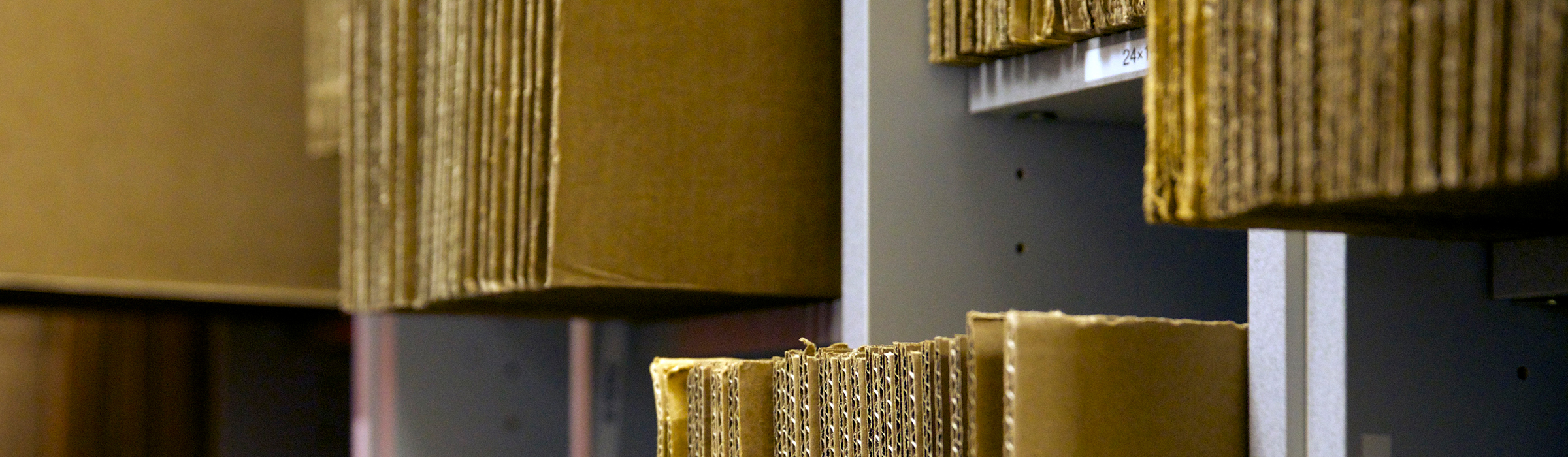 Folded brown packing boxes in cubes on shelves.